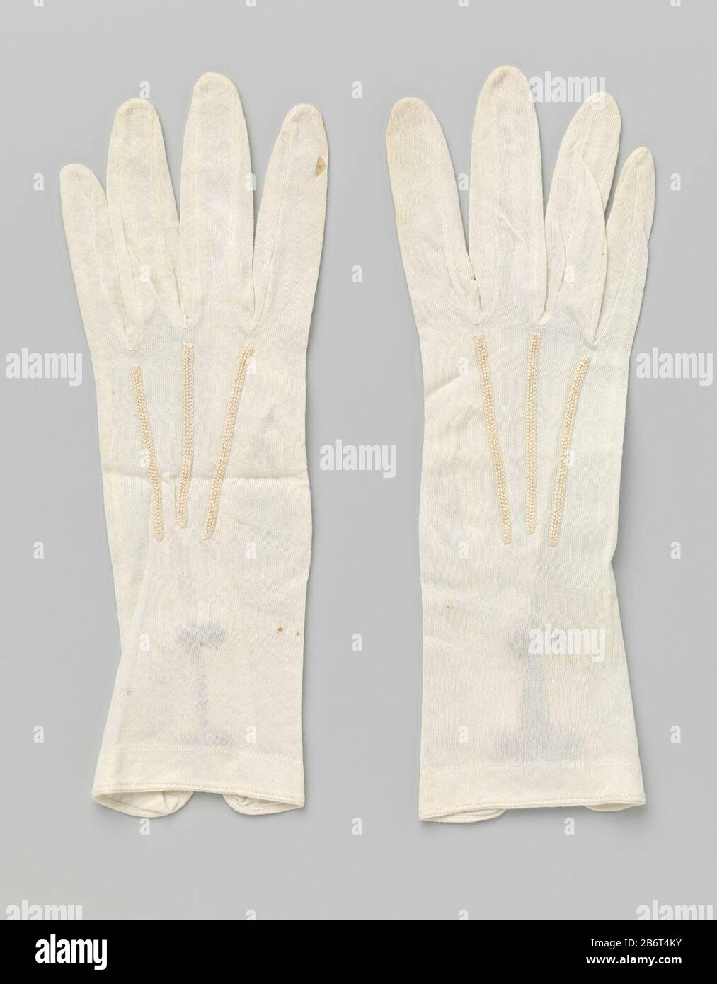 Handschoen van witte tricot met split en twee drukknopen Linker handschoen, deel van een paar, van witte katoenen tricot met split en twee drukknopen. Manufacturer : vervaardiger: anoniemPlaats manufacture: Nederland Dating: ca. 1900 - ca. 1925 Physical kenmerken: katoen, kunsstof Material: geheel: katoen knopen: kunststof tricot  Dimensions: geheel: l 25 cm.  × b 7 cm. Stock Photo