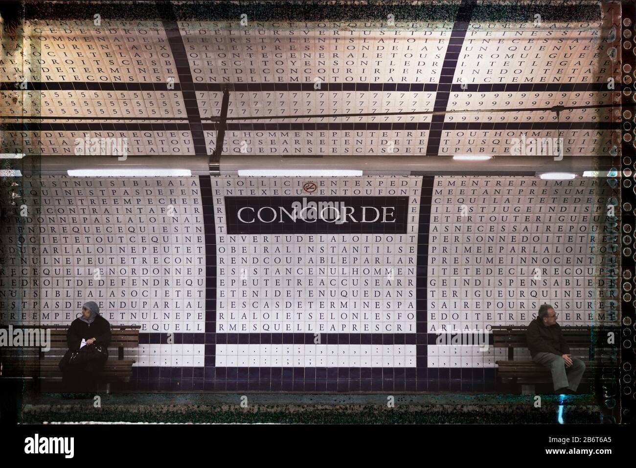 Two people facing opposite directions under a sign reading Concorde (agreement), Concorde Metro station, Right Bank, Paris, France, Europe, color Stock Photo
