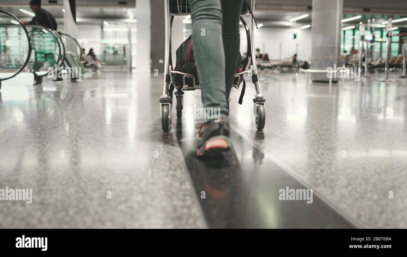 Woman Carry Luggage Cart Walk at Airport Terminal. Tracking Shot of