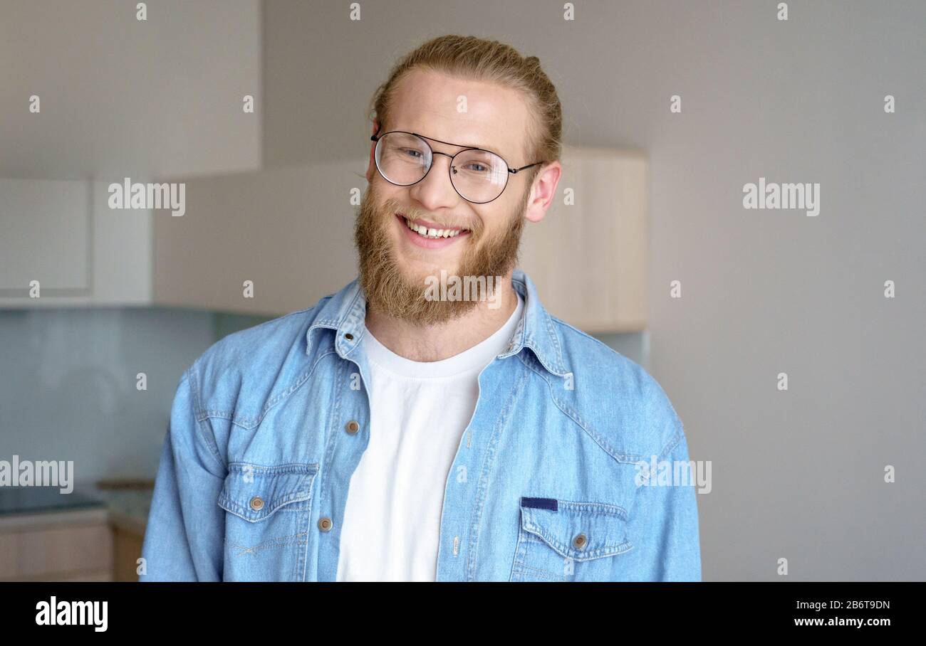 Portrait young man modern studio apartment smile at camera real estate concept. Stock Photo