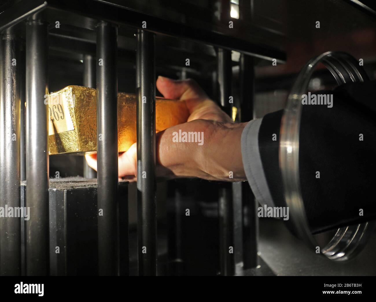 Bonn, Germany. 11th Mar, 2020. A man lifts a 12.5 kilogram gold bar of the German Gold Reserve, which is secured in a display case. The exhibition 'Wir Kapitalisten - Von Anfang bis Turbo' can be seen from 13 March to 12 July 2020 in the Bundeskunsthalle. Credit: Oliver Berg/dpa - ATTENTION: For editorial use only in connection with reporting on the exhibition/dpa/Alamy Live News Stock Photo