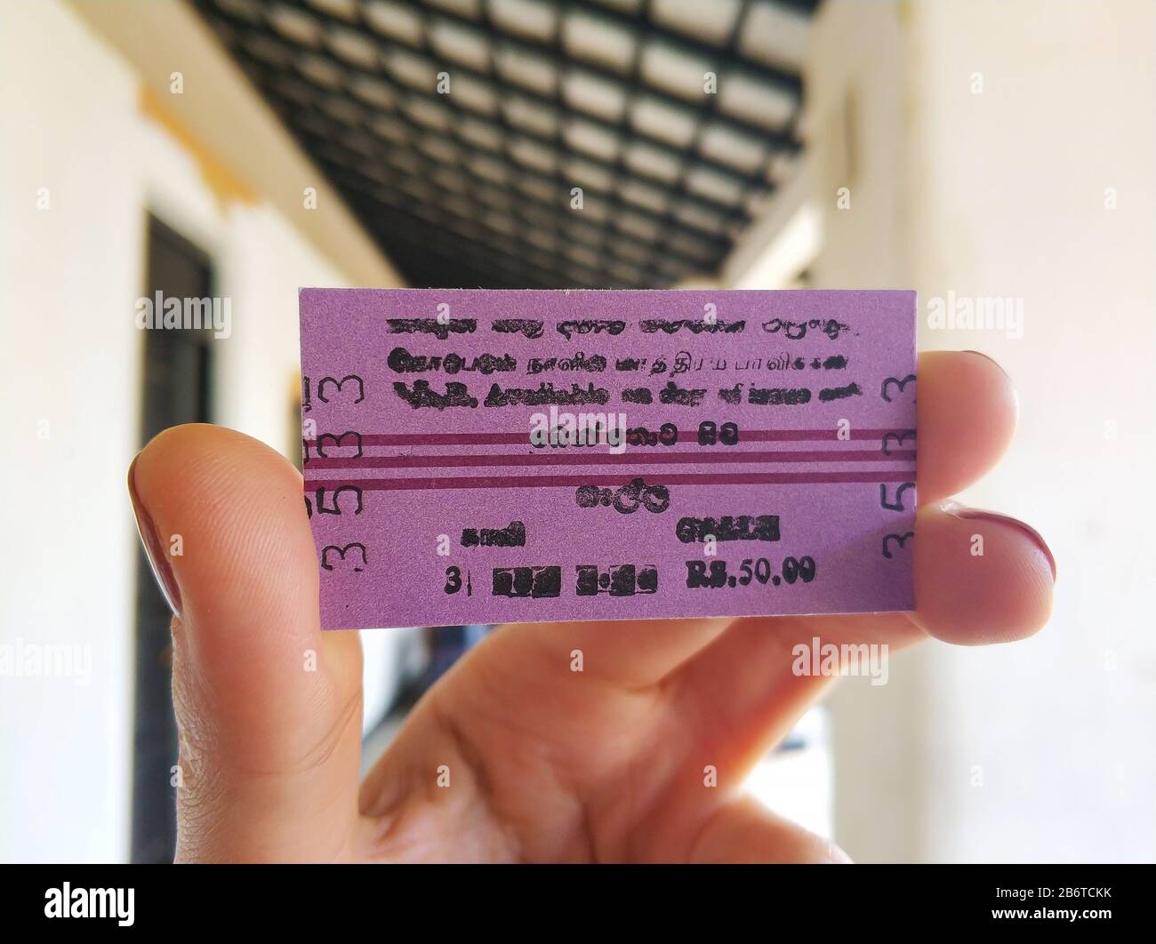 Closeup of a girl holding a train ticket in her hand. Railway in Sri
