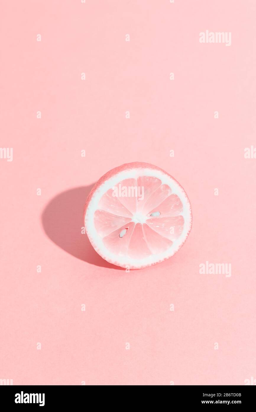 Slice of lemon with bones. Summer, youth, freshness concept. Funny pink monochrome citrus. Vertical format. Stock Photo