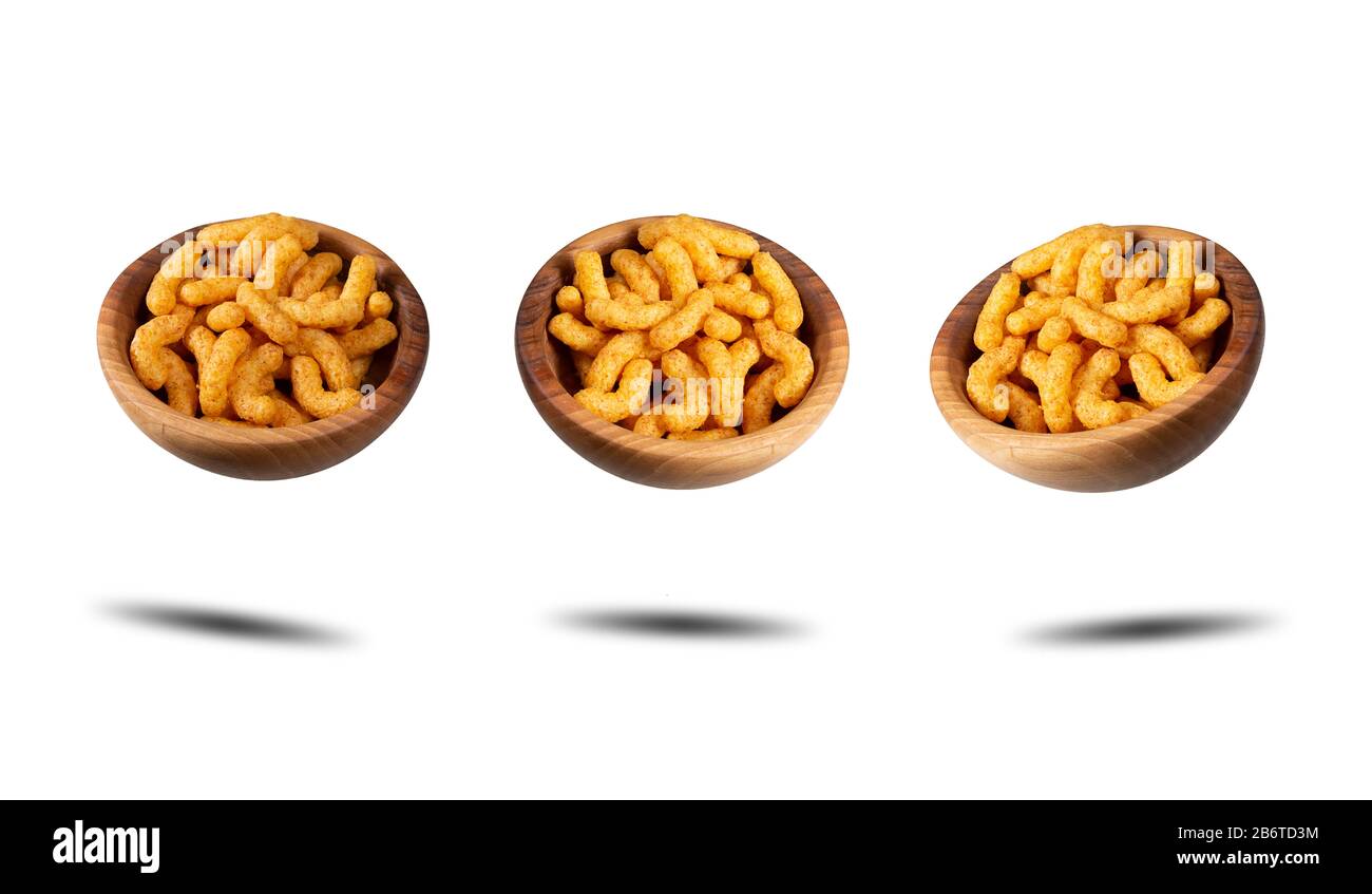 Three wooden bowls with puffed corn peanuts snacks. Isolated on white background with shadow. Banner. Photos taken from different angles. Stock Photo