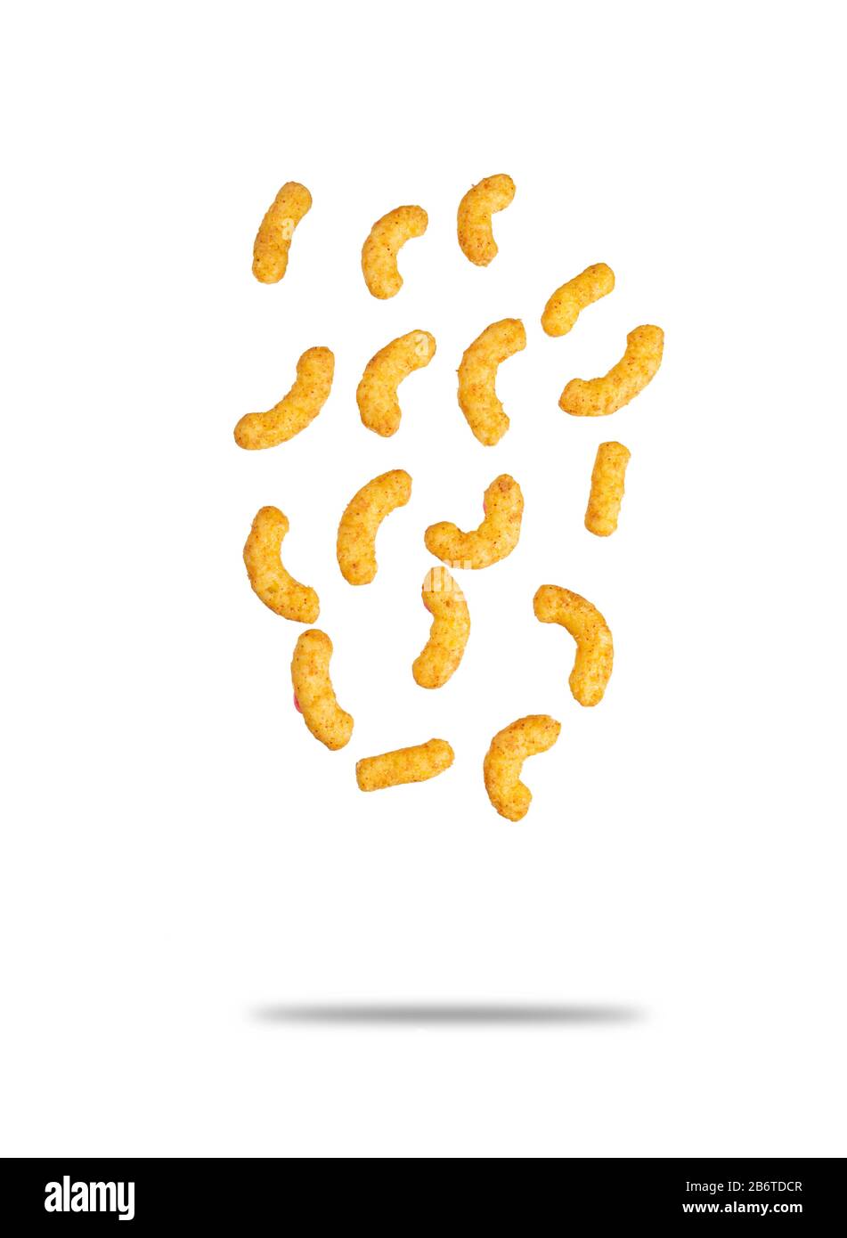 Puffed corn peanuts snacks falling. Isolated on white background with shadow. Selective focus. Stock Photo