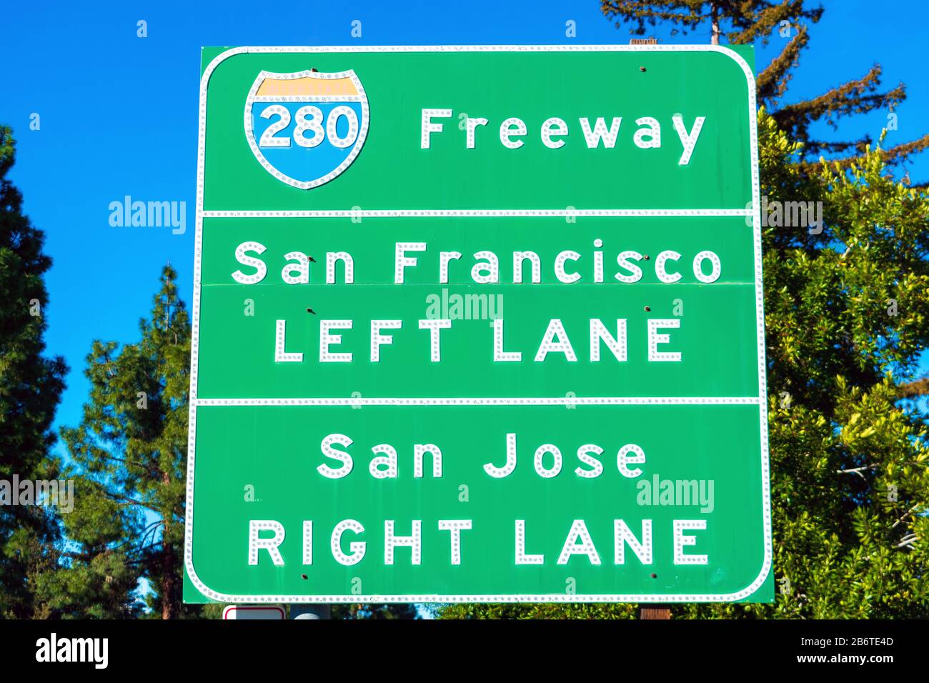 Interstate 280 highway road sign providing information to drivers the directions to San Francisco and San Jose in sunny Silicon Valley. Green trees an Stock Photo