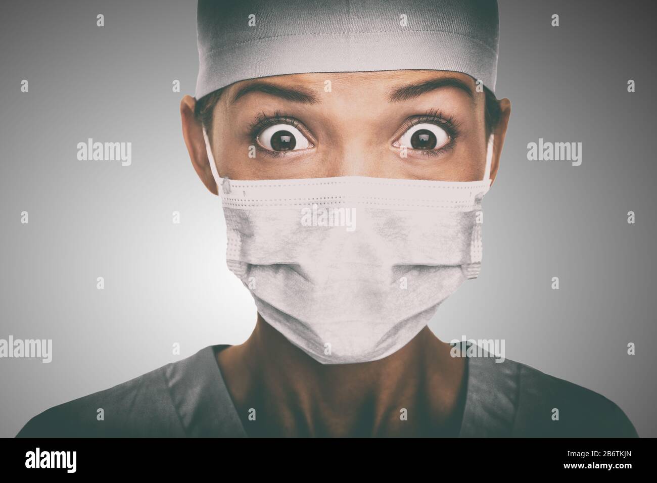 Virus scare Asian doctor woman shocked wearing coronavirus mask protection looking scared. China hospital staff. Stock Photo