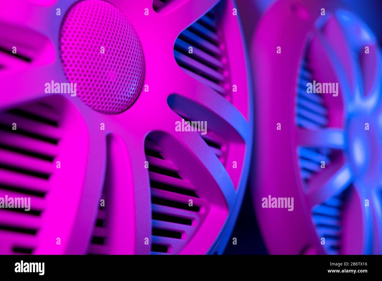 Colorful lights of car stereo and car speakers background.  Car music audio speaker in blue and pink tones. Modern car audio system close up Stock Photo