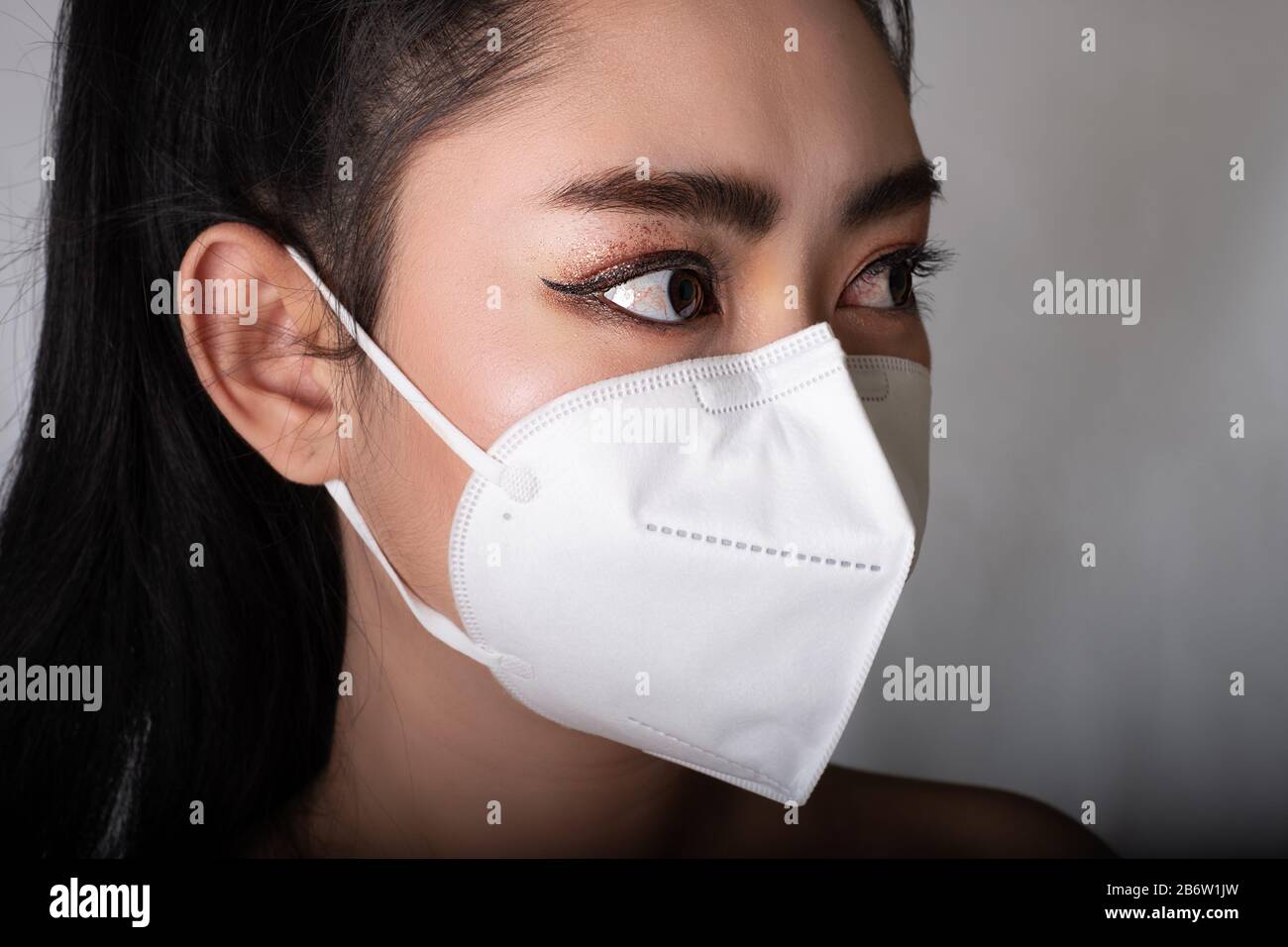 Close up of a woman putting on a respirator N95 mask to protect from ...