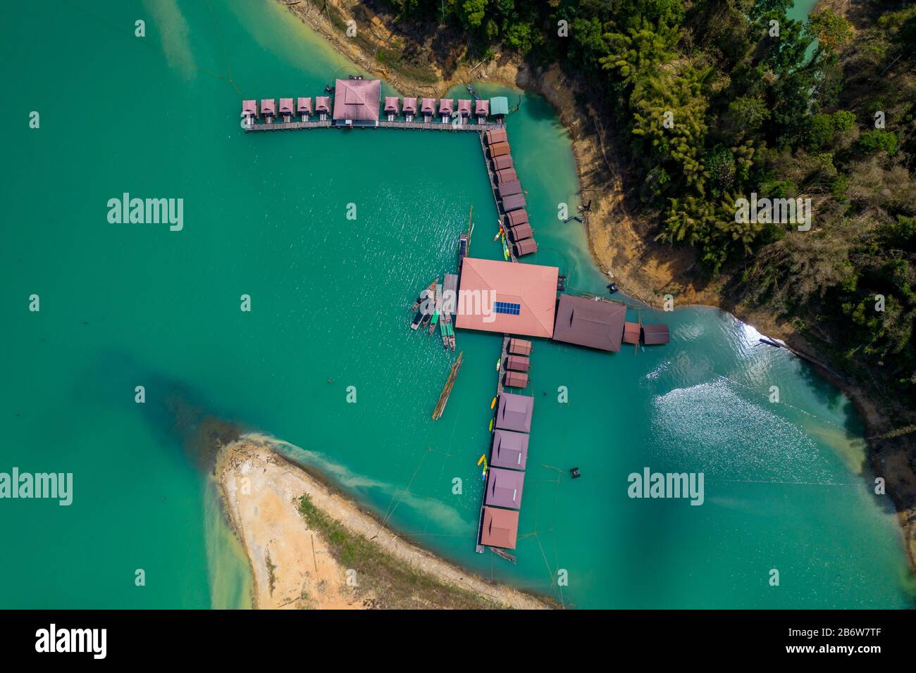 Aerial drone view of a floating wooden rafthouse surrounded by huge cliffs and tropical jungle (Khao Sok) Stock Photo