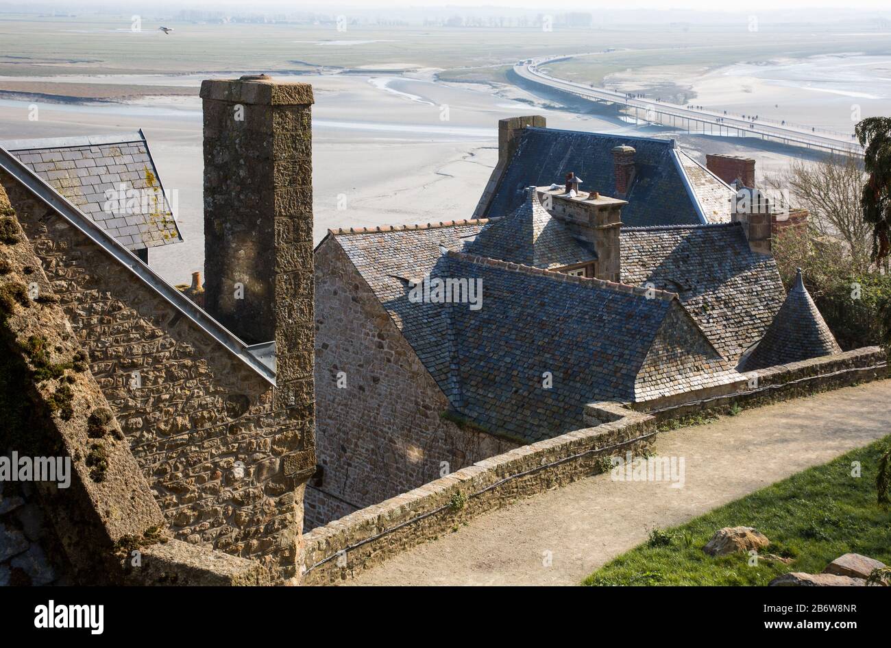 Mont-Saint-Michel, Klosterberg, Weg oberhalb des Dorfes, hinten Damm und Brücke Stock Photo