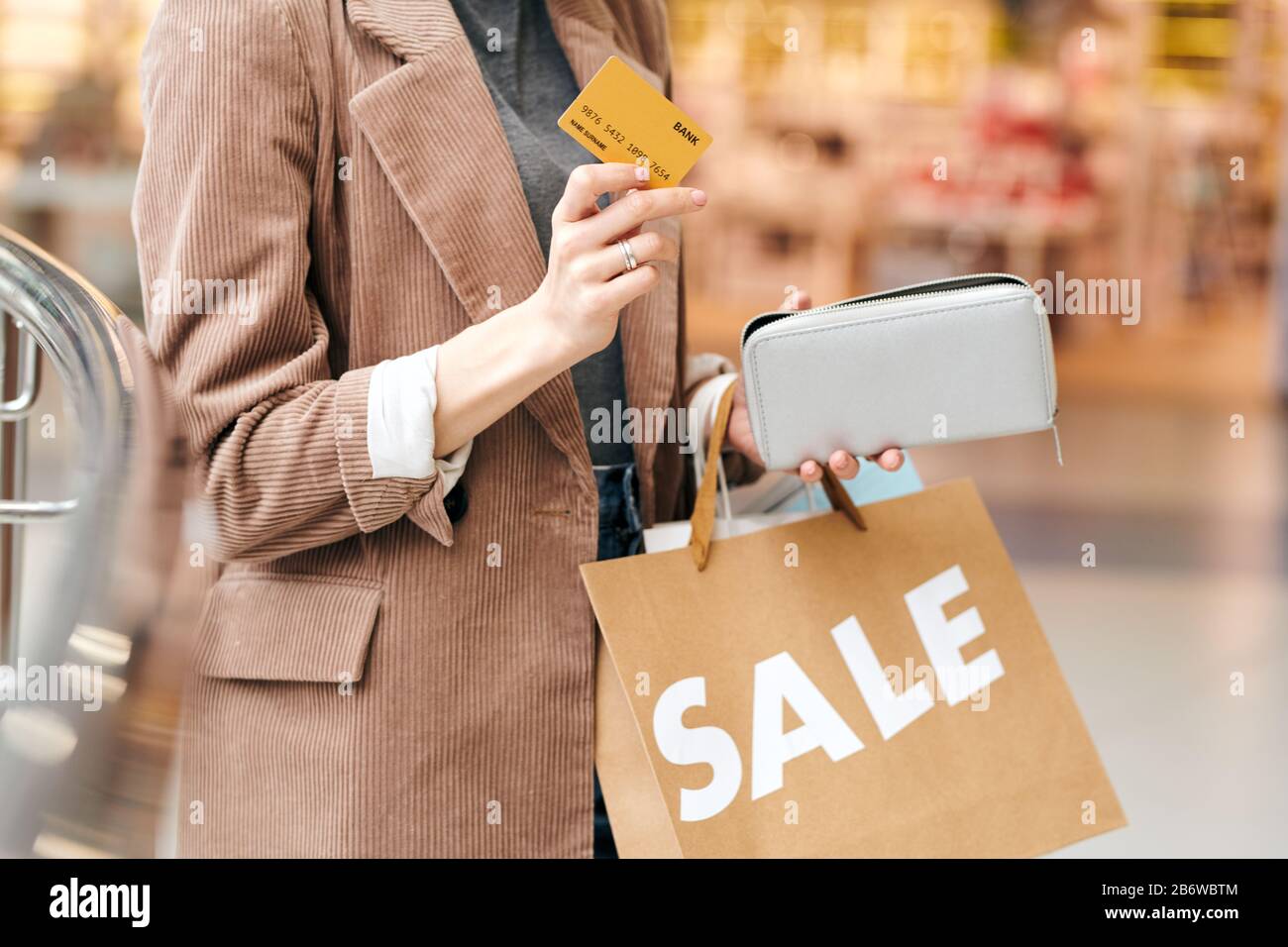 Close-up of unrecognizable woman in velvet jacket holding credit card and purse while preparing to spend money for shopping Stock Photo