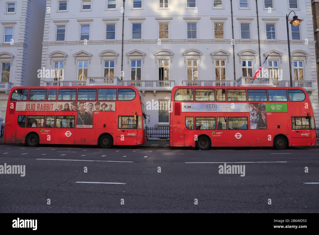 Two red double decker buses are parked outside the listed buildings used by Lycée Francais Charles de Gaulle school in Cromwell Road,  London, UK. Stock Photo