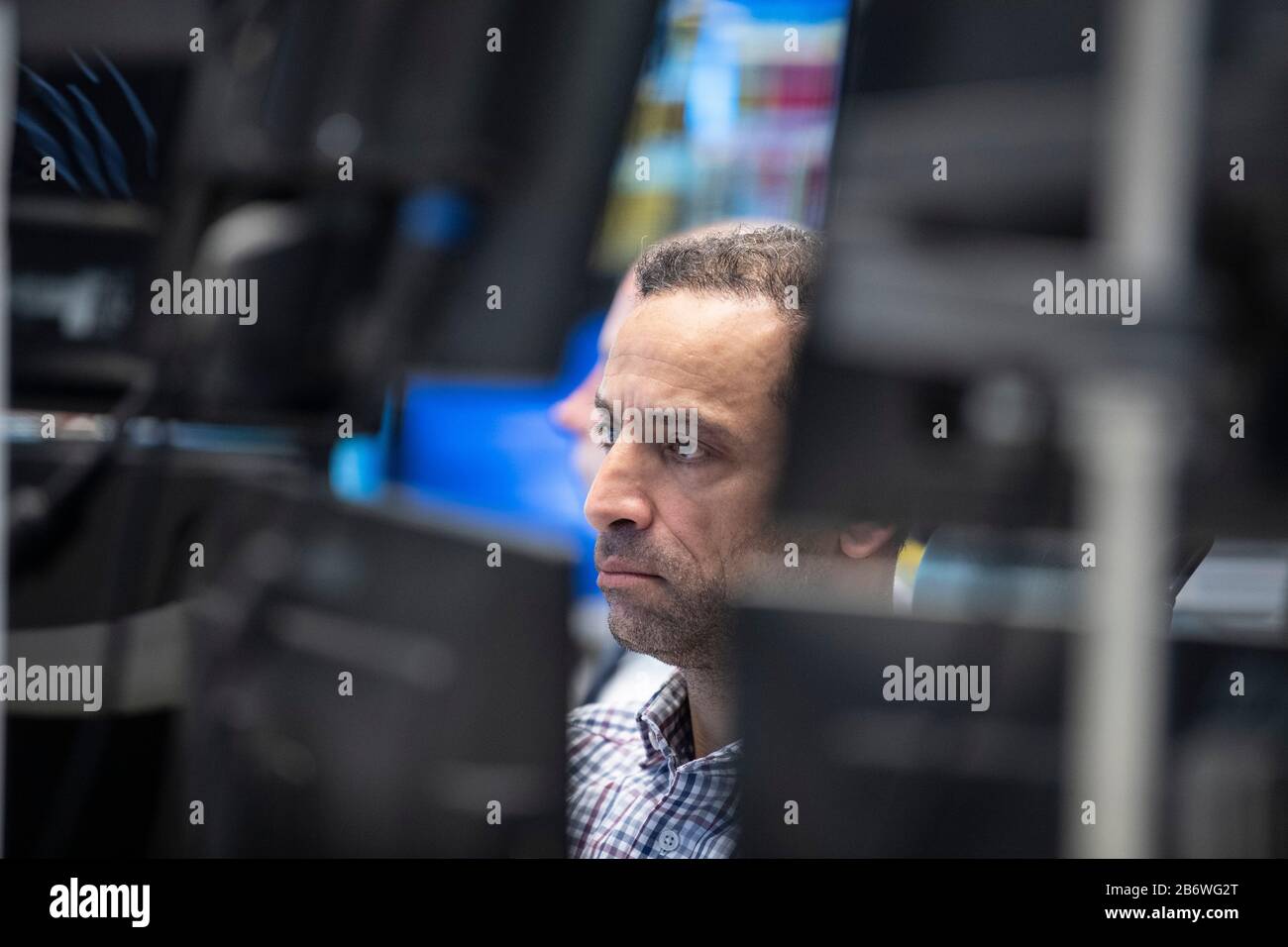 12 March 2020, Hessen, Frankfurt/Main: Traders in the trading room of the Frankfurt Stock Exchange follow the price development on their monitors. At the start of trading, the Deutsche Aktien Index (DAX) had fallen below the 10,000 point mark for the first time since 2018. Photo: Boris Roessler/dpa Stock Photo
