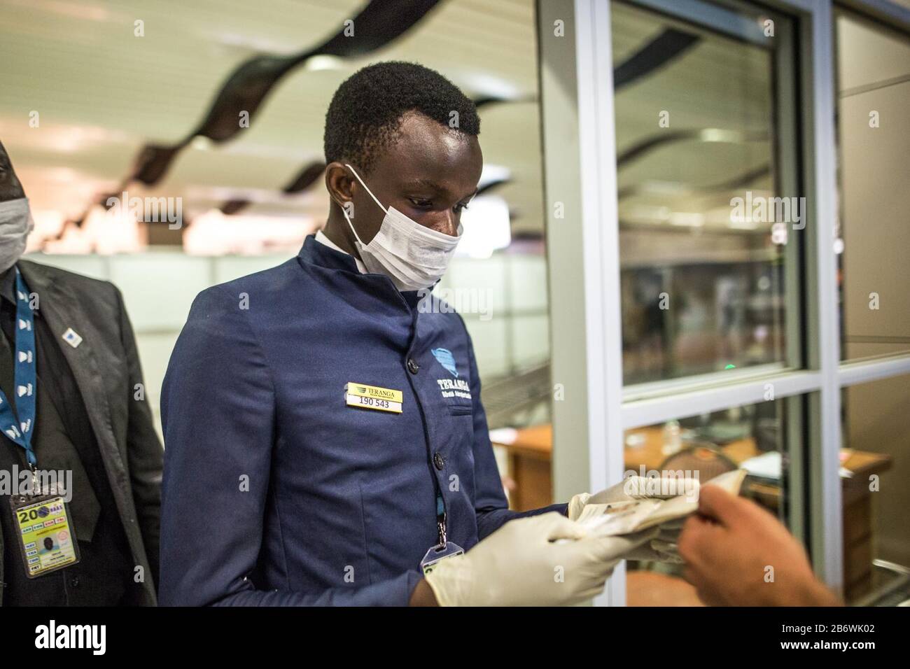 Dakar, Senegal. 10th Mar, 2020. An airport employee wearing face mask checks passports at the entrance of the airport, in Dakar, Senegal, March 10, 2020. Senegalese Ministry of Health and Social Action confirmed the country's fifth case of the COVID-19 on Wednesday. In order to prevent more cases from entering Senegal, the authorities of Blaise Diagne International Airport, under the guideline of Senegalese Ministry of Health and Social Action, have intensified all the necessary measures to detect cases of the novel coronavirus. Credit: Eddy Peters/Xinhua/Alamy Live News Stock Photo