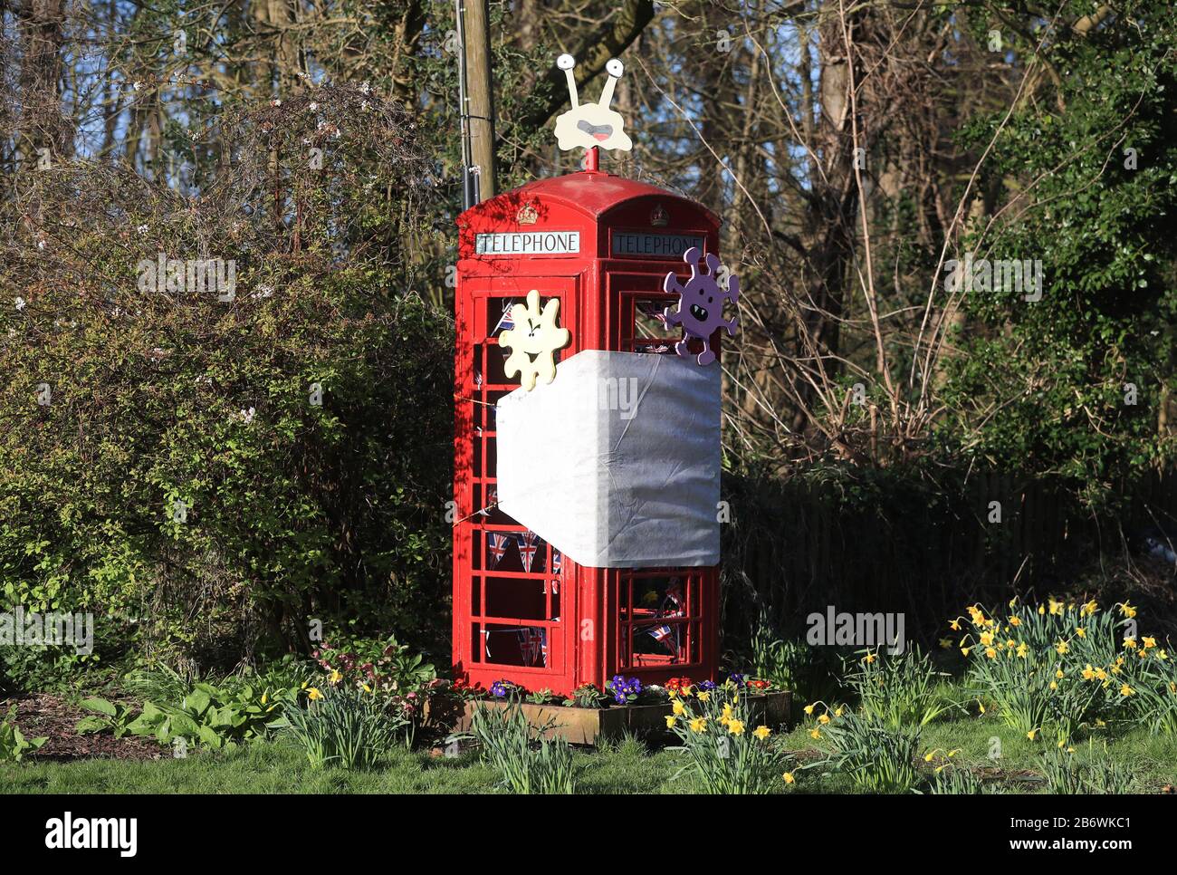 A decommissioned telephone box in the village of Orston, Nottinghamshire, which local residents have decorated with a so-called coronavirus theme, including a giant face mask and cartoon germs. Stock Photo