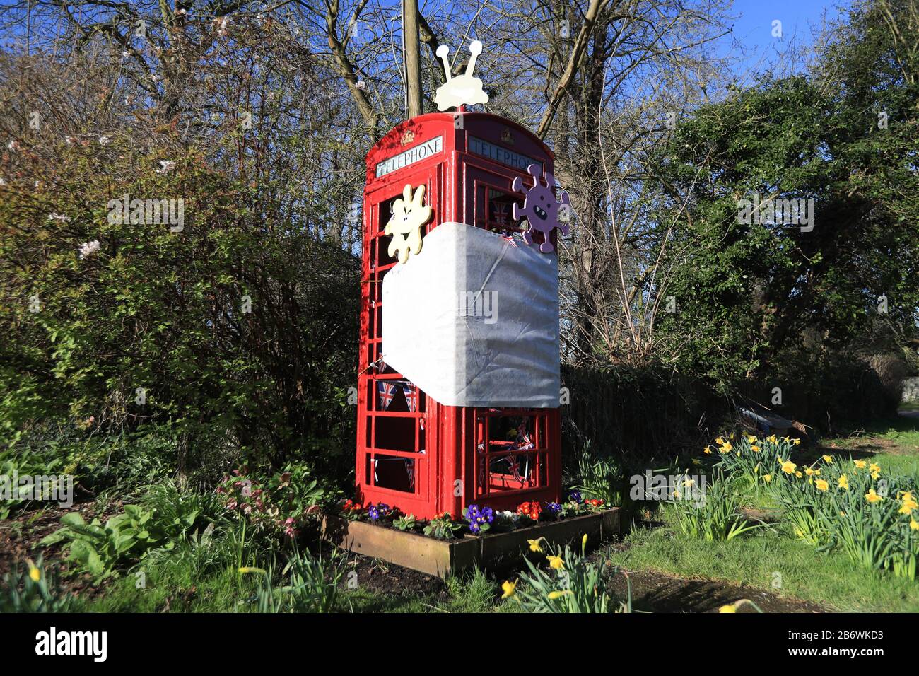 A decommissioned telephone box in the village of Orston, Nottinghamshire, which local residents have decorated with a so-called coronavirus theme, including a giant face mask and cartoon germs. Stock Photo