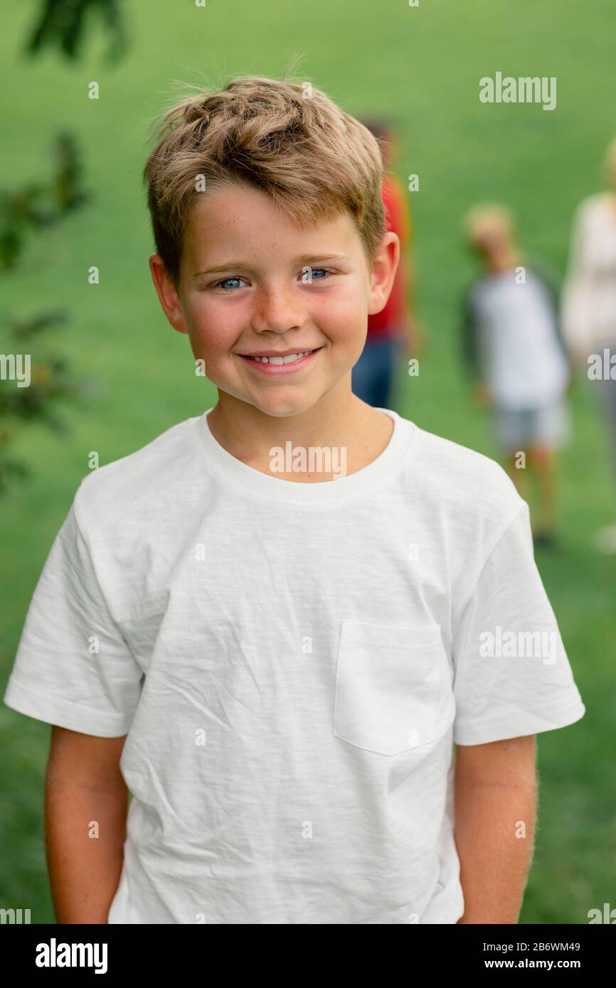 A front view shot of a young boy smiling and looking at the camera. Stock Photo