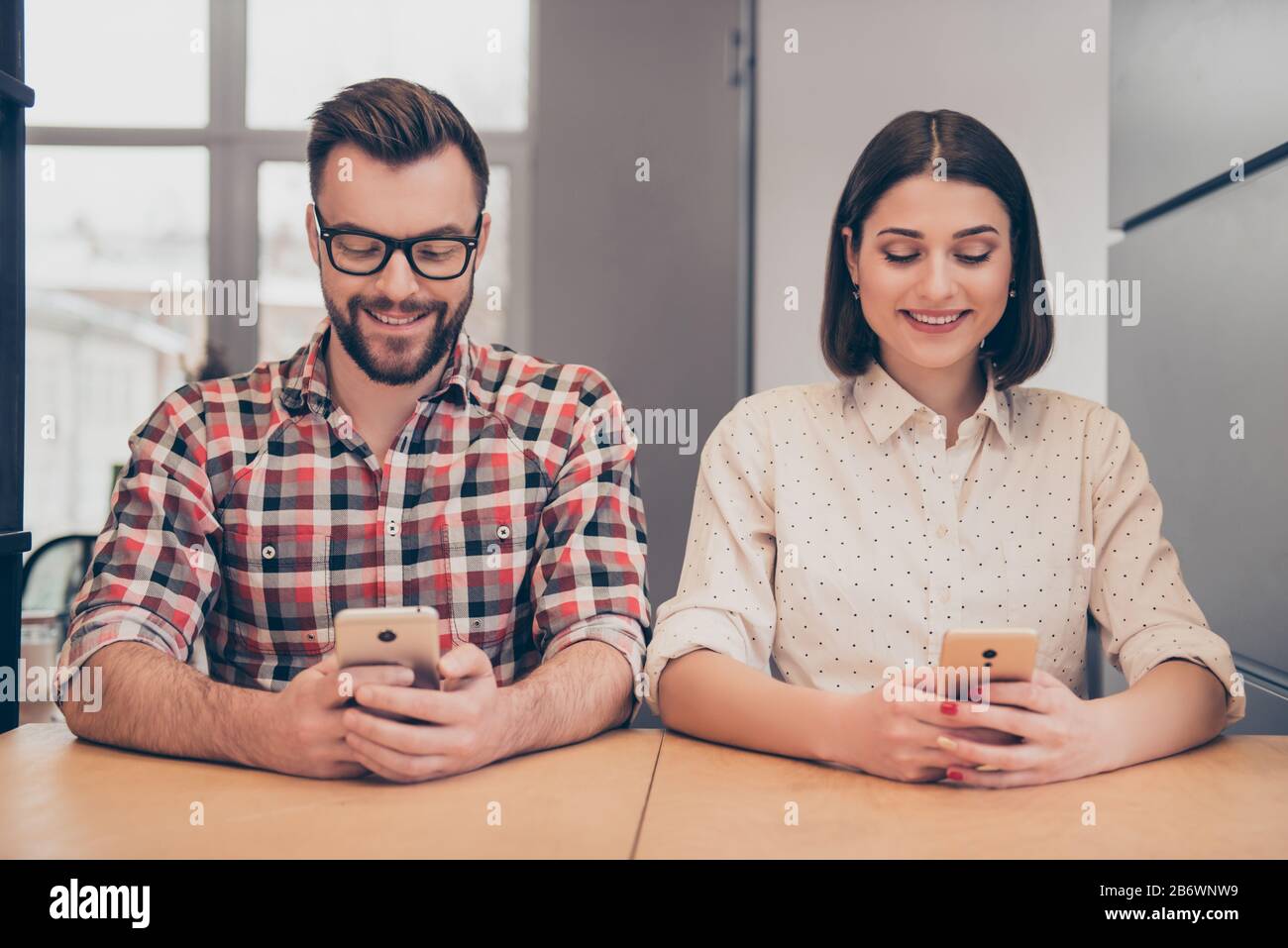 Two happy young colleagues writing hi-res stock photography and images ...