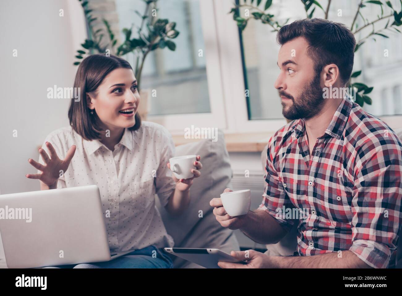 Two young managers with coffee discussing creative ideas. Stock Photo