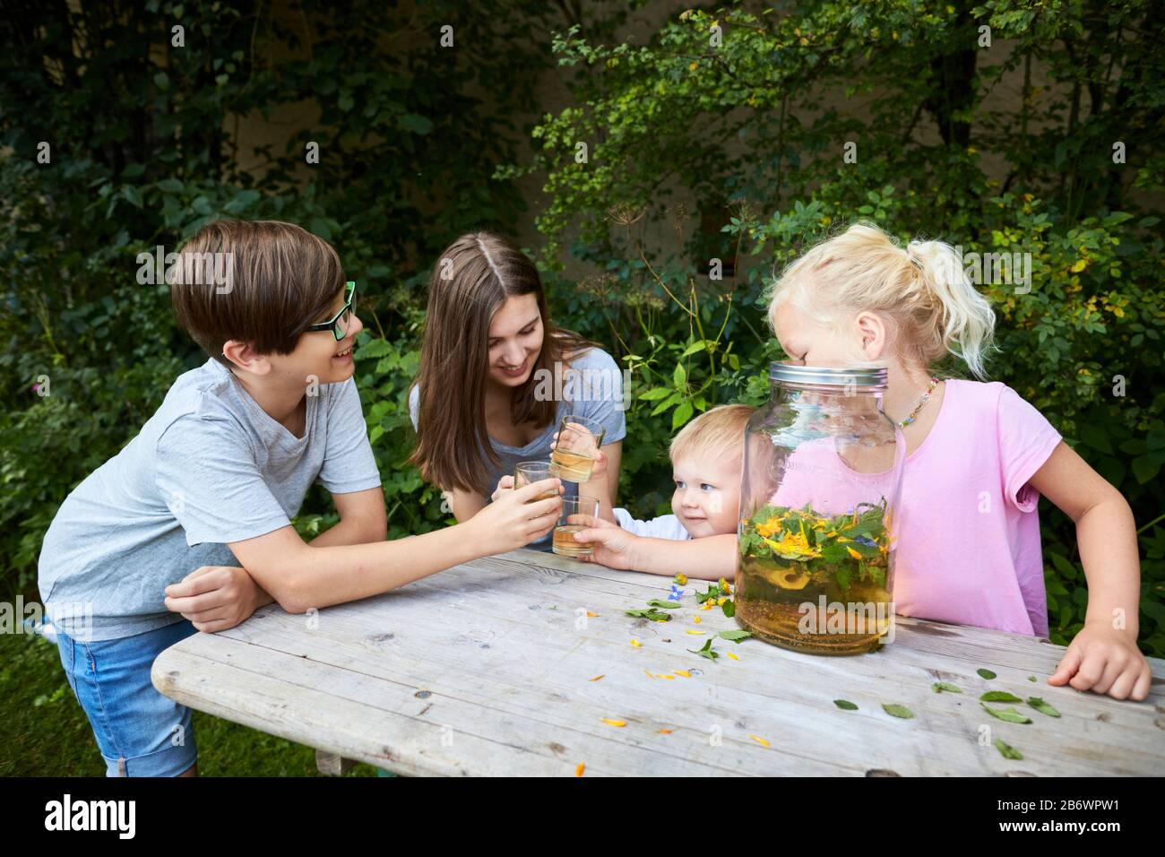 Children investigating food. Series: Preparation of a herbal drink. Tasting the ready drink. Learning according to the Reggio Pedagogy principle, playful understanding and discovery. Germany. Stock Photo