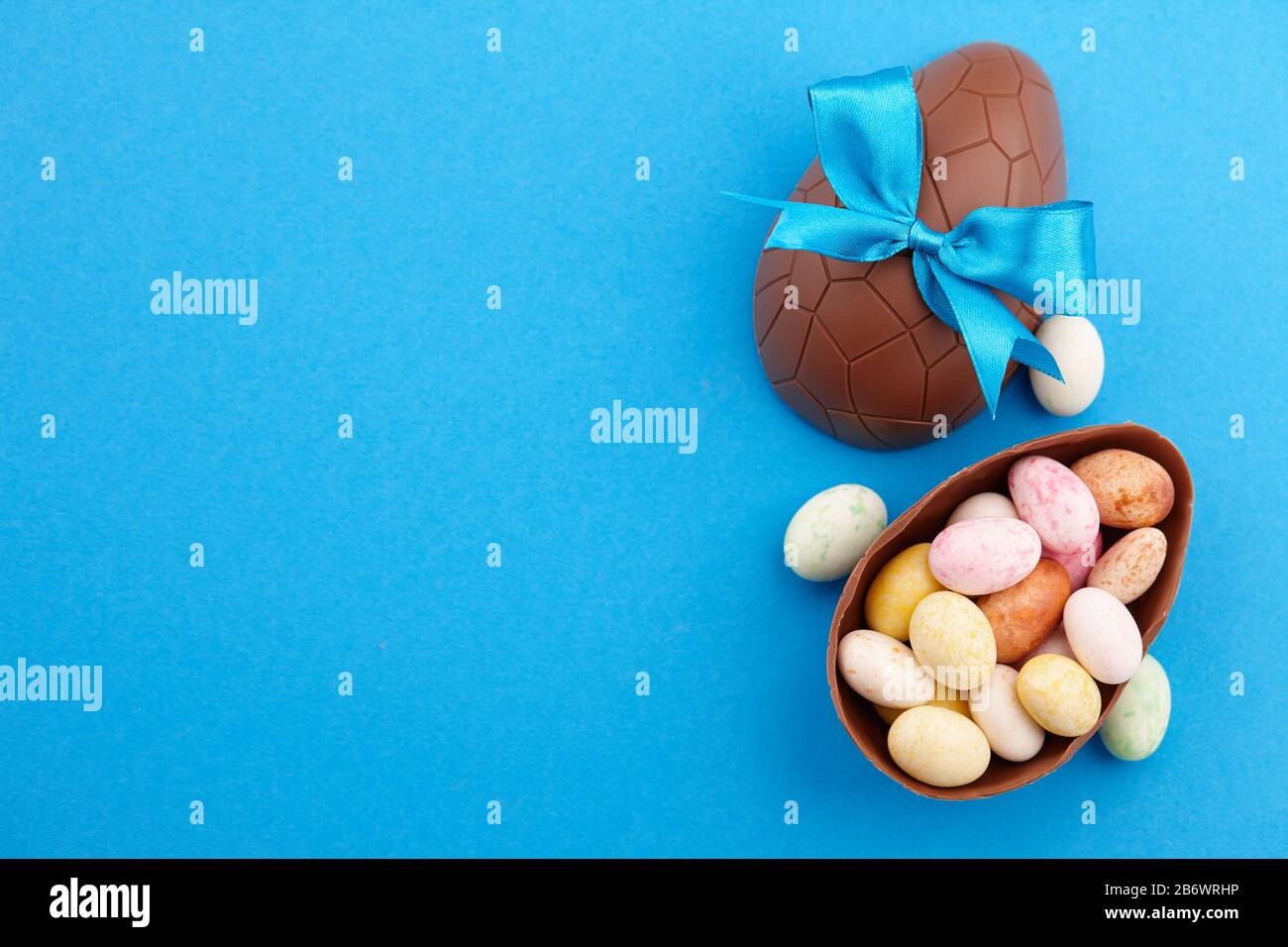 Chocolate Easter eggs with colorful candies Stock Photo