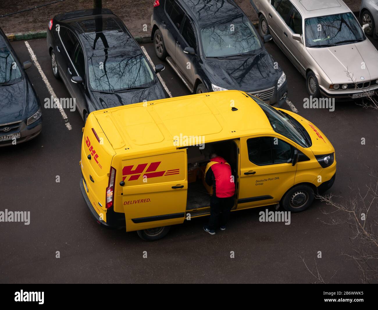 Moscow, Russia - March 11, 2020: DHL Deutsche Post courier in yellow-red  uniform near minivan with company logos. DHL International GmbH is world  larg Stock Photo - Alamy