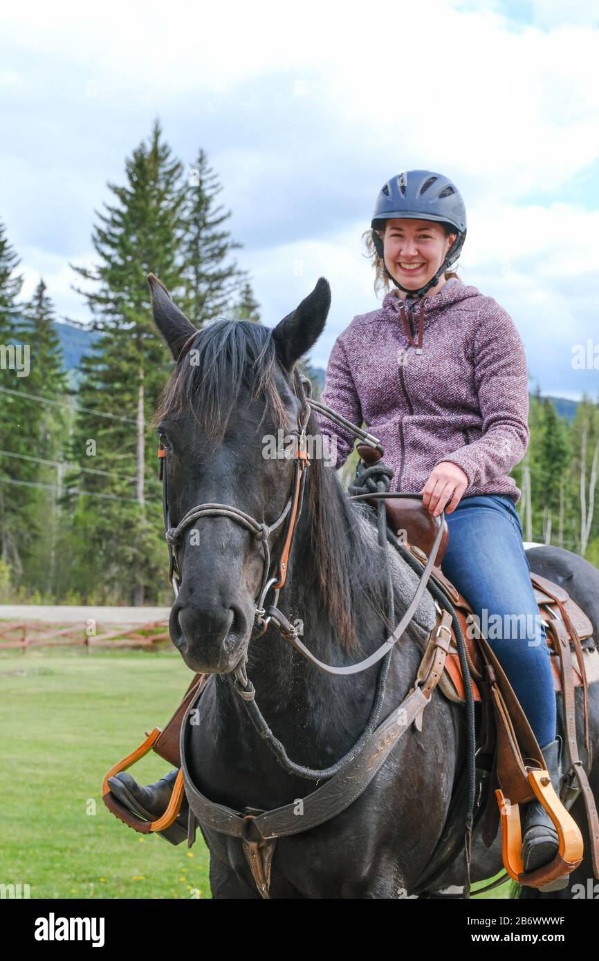 A young woman riding a horse, part of horse, front view in Banff