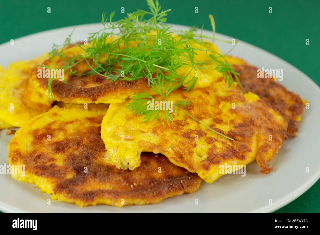 Keto recipe. Cream cheese pancakes. On a green background. Stock Photo