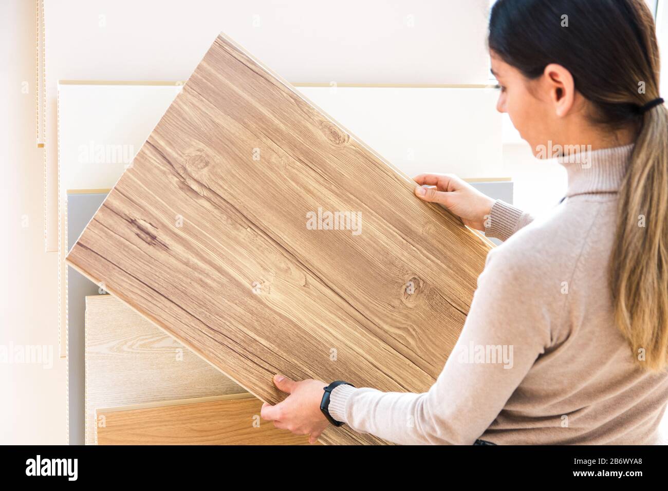 woman choosing wood laminated flooring in shop. home repair Stock Photo