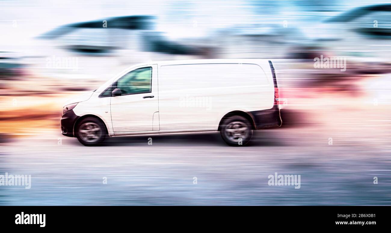 White delivery van speeding on road with blurred background. Stock Photo