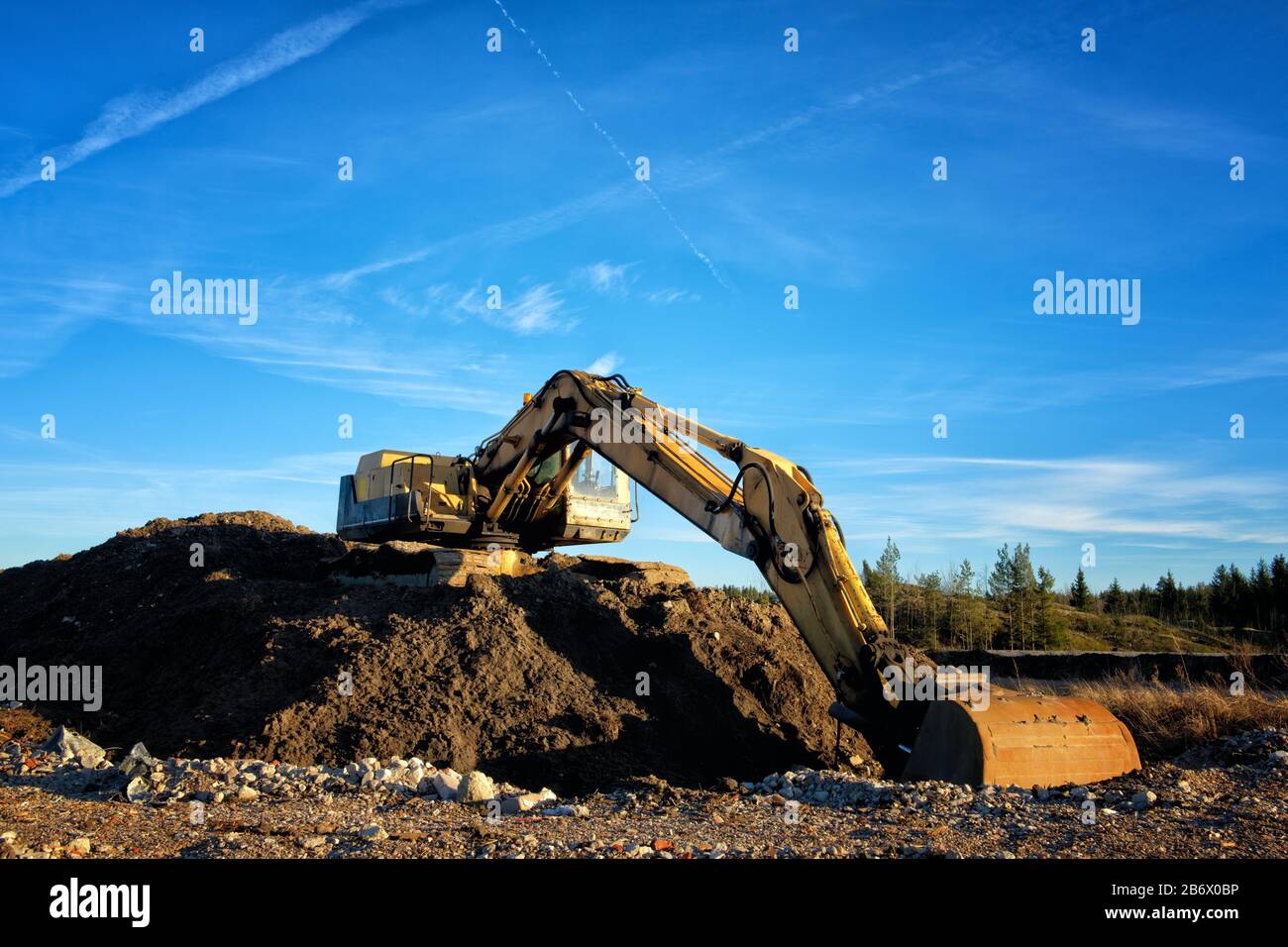 Yellow excavator on a road construction site against blue sky Stock ...