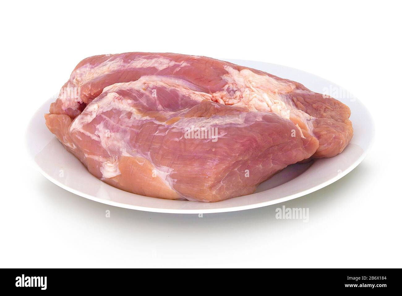 Raw gigot on ceramic plate. Isolated on white background with shadow reflection. With clipping path. With vector path. Joint of pork on white bg. Raw Stock Photo