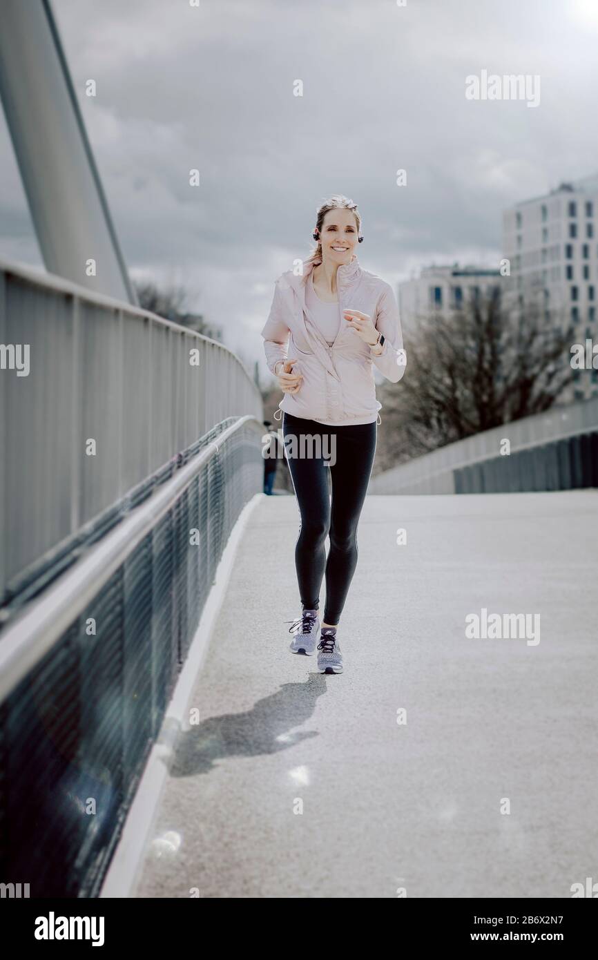 Junge Sportlerin macht Sport in der Stadt. Jogging in der Stadt.  Young sportswoman does sports in the city Stock Photo