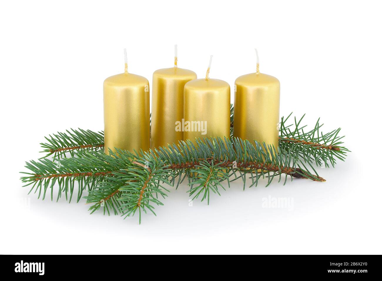 Advent candles with coniferous twigs. Isolated on white background with natural shadow. Composition of advent candles of gold color and coniferous twi Stock Photo