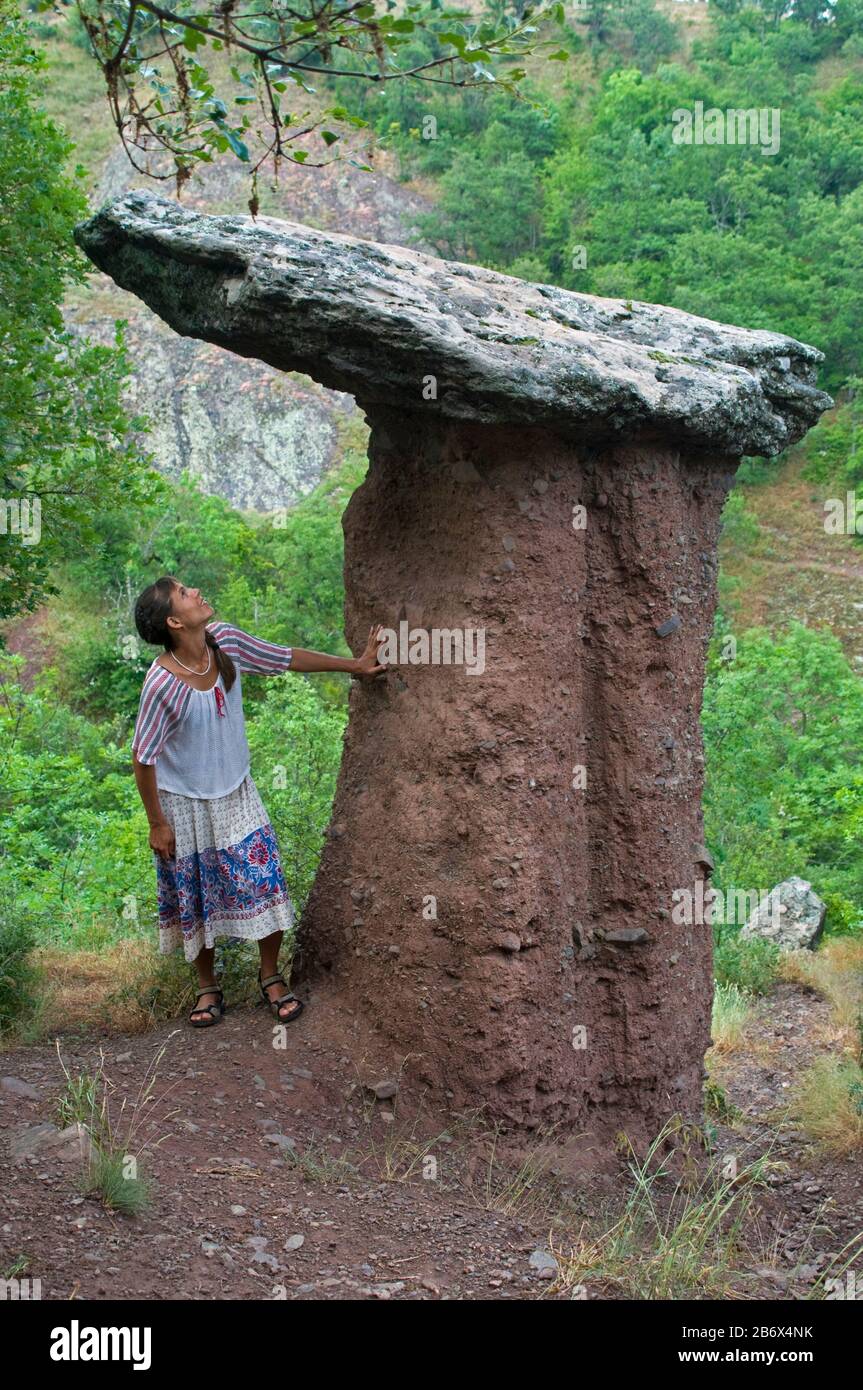 Woman looks at nature wonder - stone mushroom. This landmark (Sotera valley) is in Crimea - near Alushta . Stock Photo