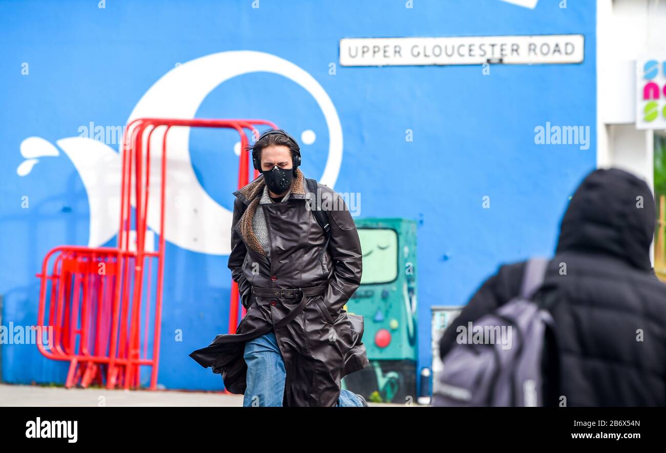 Brighton UK 12th March 2020 - A man wearing a face mask walks through Brighton today as the British government is expected to bring in the delay phase to help combat the Coronavirus COVID-19 pandemic  . Credit: Simon Dack / Alamy Live News Stock Photo