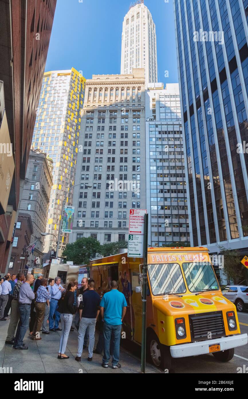 Lower Manhattan street scene, New York, New York State, United States of America.  Customers gathered around fast food trucks. Stock Photo