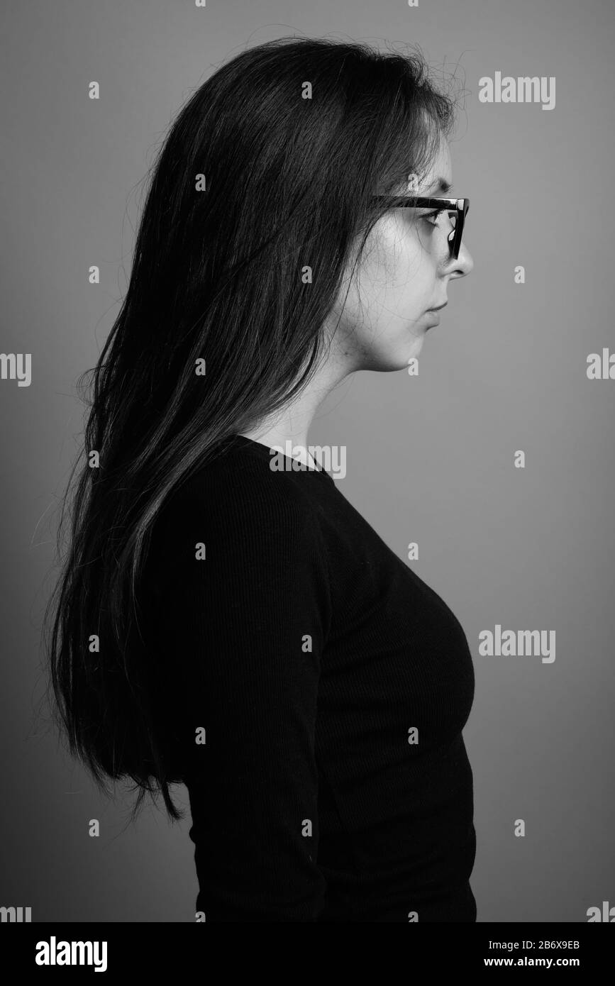 Portrait of young beautiful woman against gray background Stock Photo ...