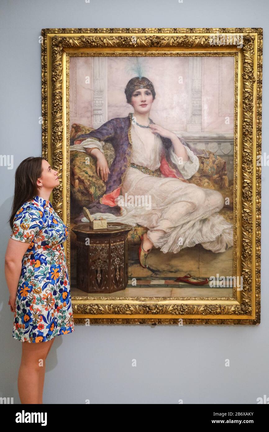 London, UK. 12th Mar, 2020. An assistant poses with William Clarke Wontner's 'Jade Necklace for an Eastern Princess', 1908. 'The Enchanted Interior', challenges the historic depiction of women in art with Pre-Raphaelite and contemporary female artists' works. The exhibition runs 13th March to 14th June, 2020. Credit: Imageplotter/Alamy Live News Stock Photo