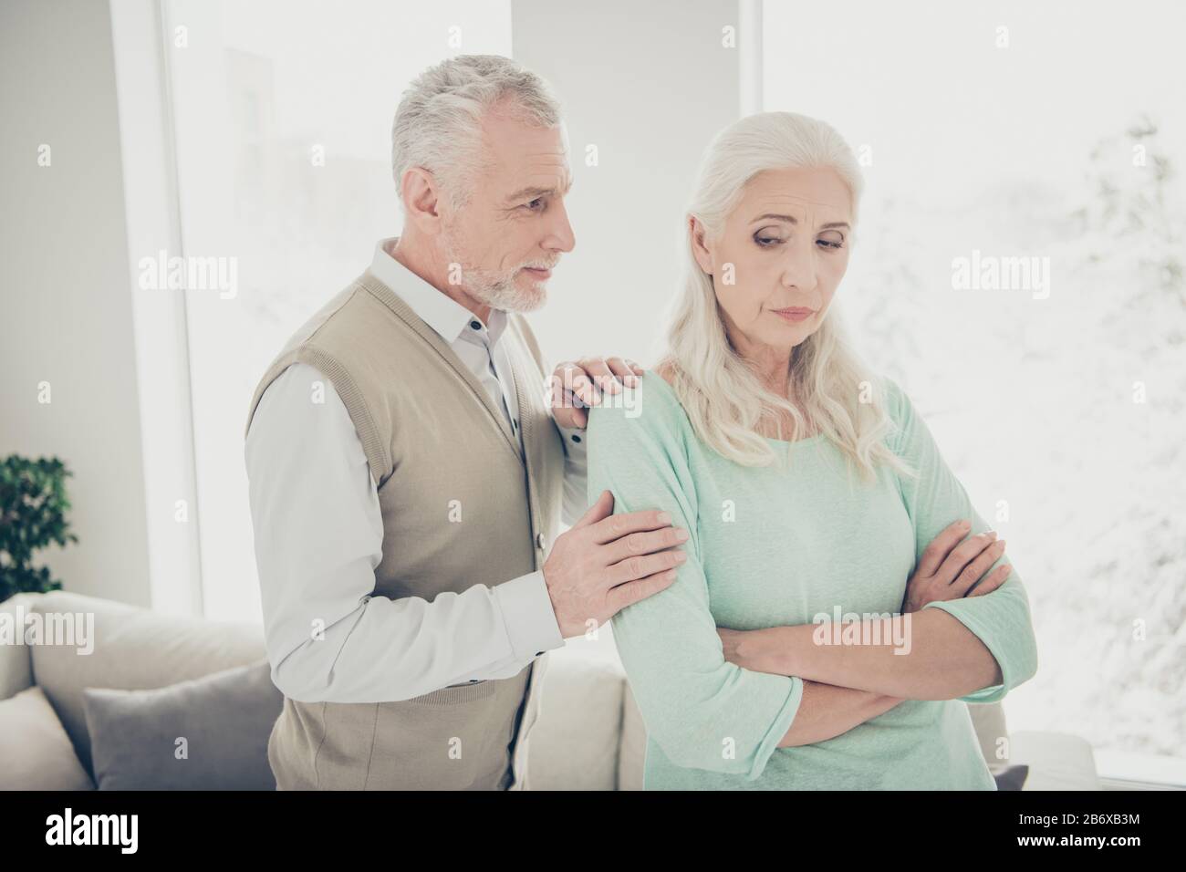 Close-up photo of happy smiling optimistic husband trying to calm down his jealous lady Stock Photo