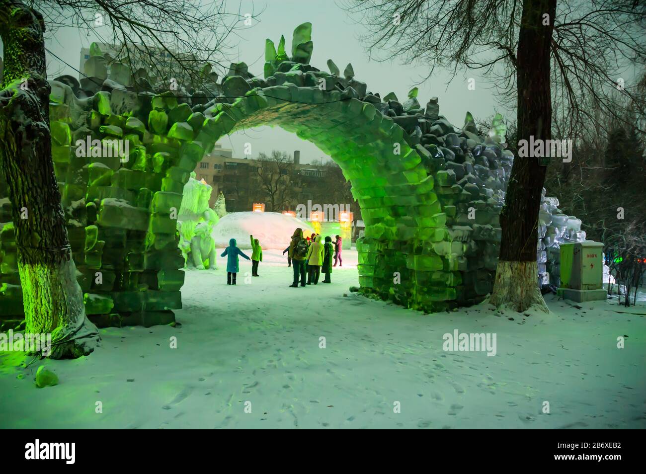 Tourists framed by an ice bridge at dusk in Harbin’s Zhaolin Park. Stock Photo
