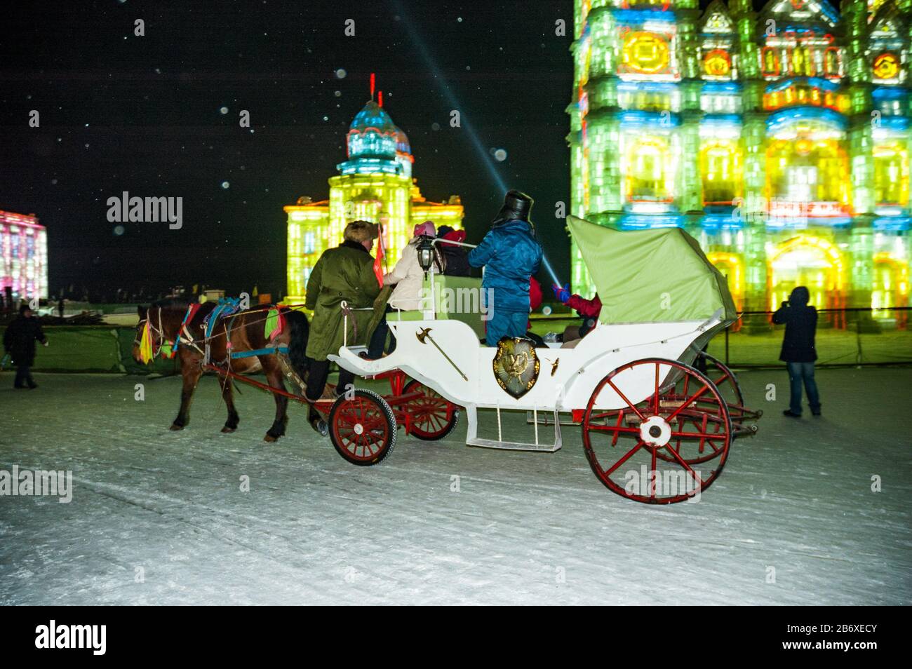 A horse and carriage takes tourists through Snow & Ice World in Harbin. Stock Photo
