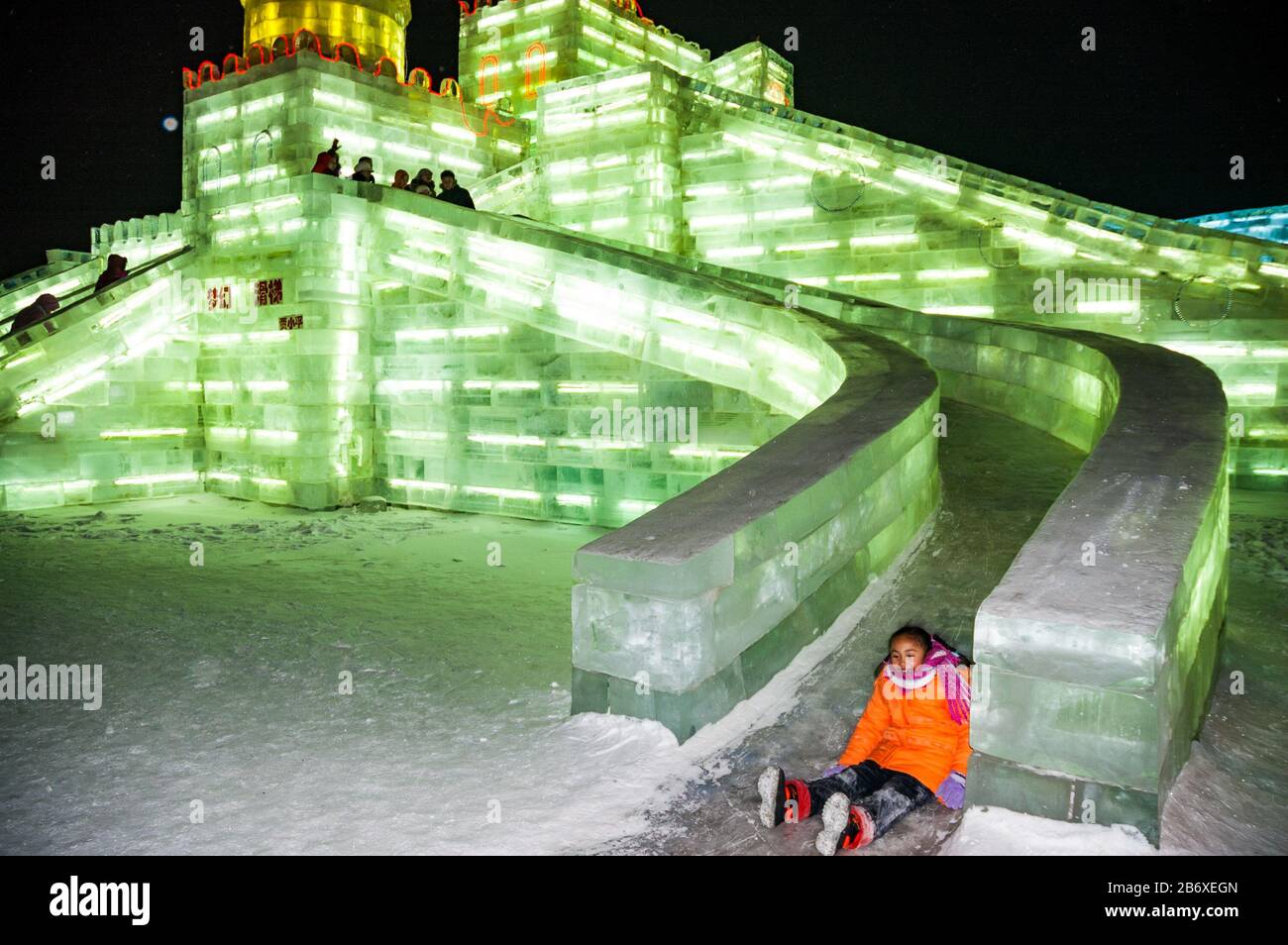 A child enjoys an ice slide at Snow & Ice World in Harbin. Stock Photo