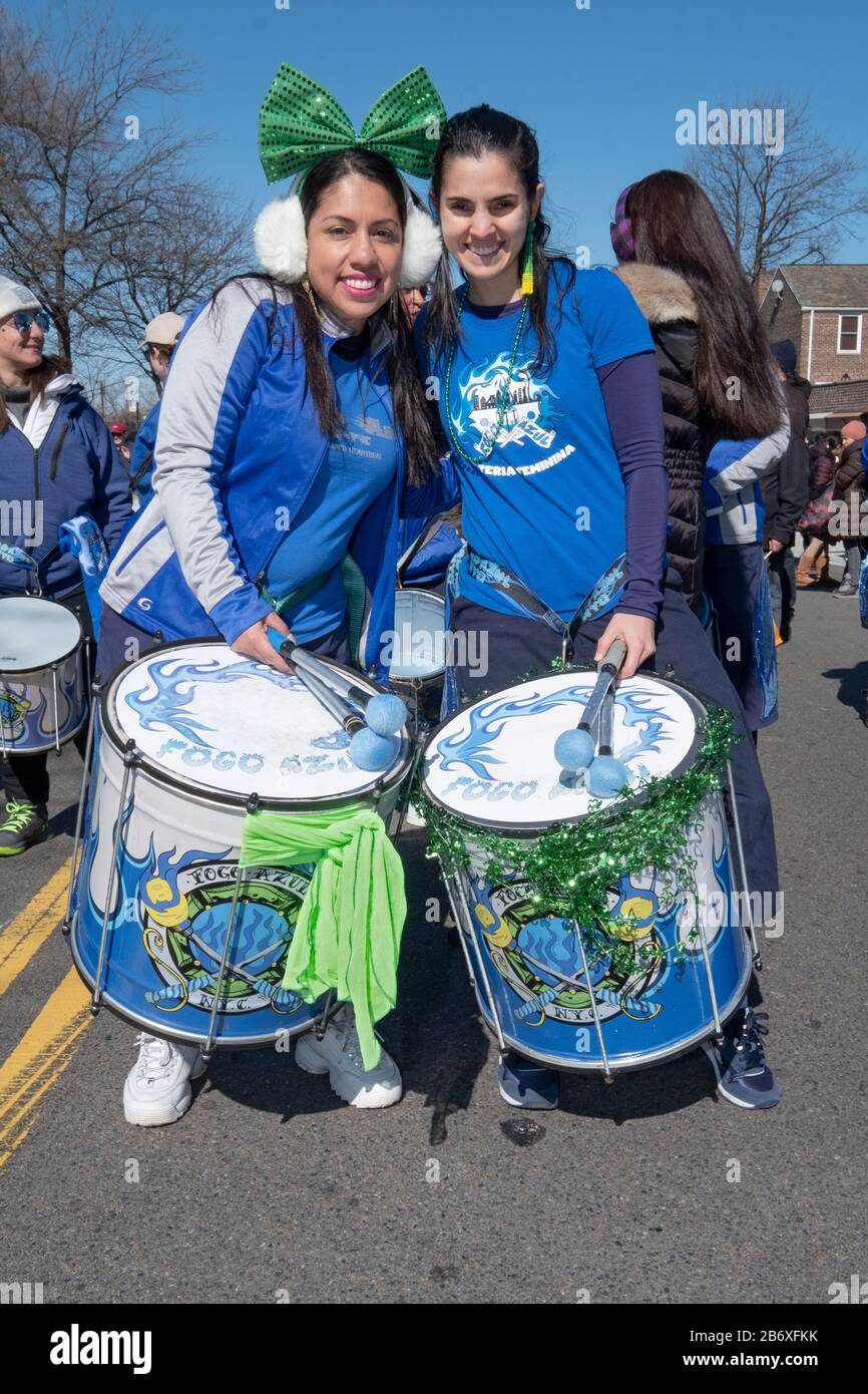 2 members of the Fogo Azul all-female drumline marching band prior to marching in the St. Patrick's Day Parade for All in Sunnyside, Queens, NYC. Stock Photo