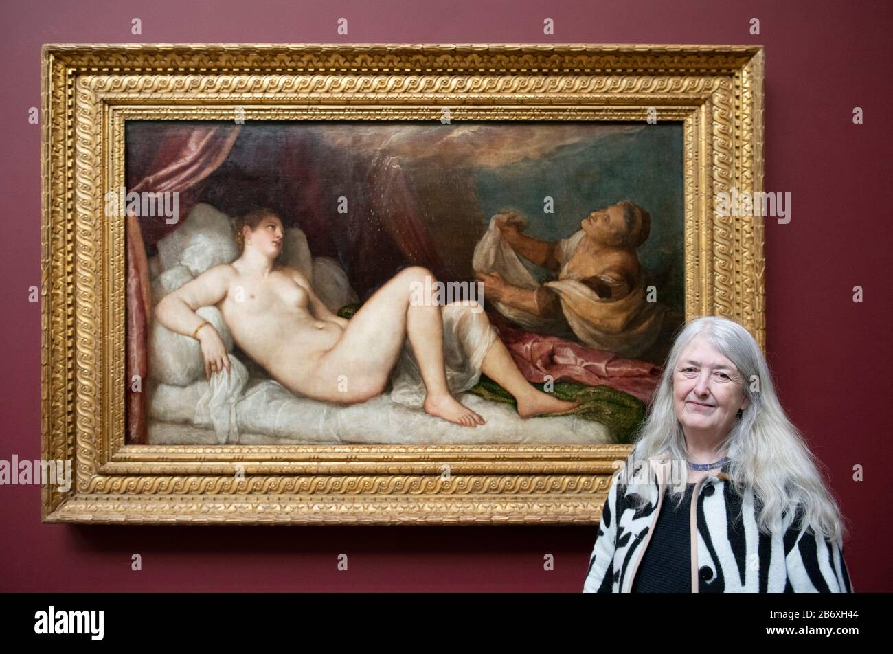 The National Gallery, London, UK. 12th March 2020. Titian: Love Desire Death, a major exhibition which brings together Titian’s complete cycle of paintings known as the poesie and inspired by Greek myths for the first time since the late 16th century. Image: Classical scholar and historian Dame Mary Beard in front of Titian’s Danae, 1551-3. Wellington Collection, Apsley House, London. After closing during Coronavirus Lockdown the exhibition Titian: Love, Desire, Death opens on 8th July 2020 and is extended until 17 Jan 2021. Credit: Malcolm Park/Alamy Live News. Stock Photo