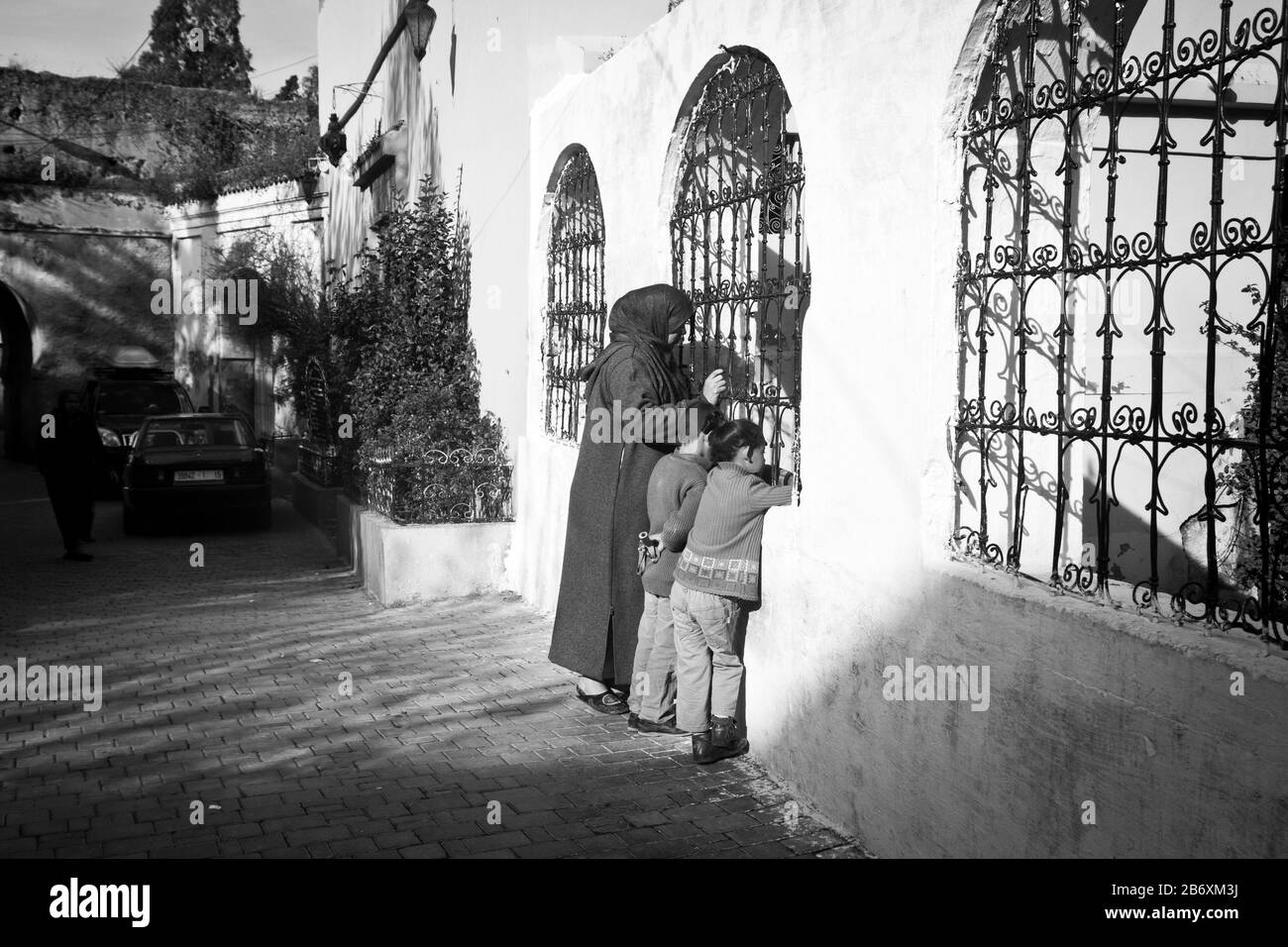 A woman and children look into a courtyard in Fes, Morocco Stock Photo