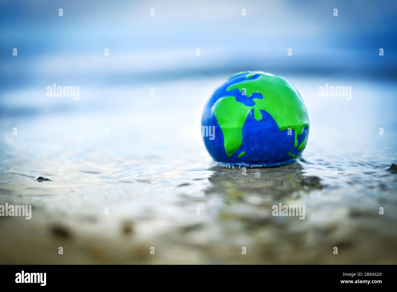 Erdkugel im Wasser, Symbolfoto fuer den Anstieg des Meeresspiegels durch den Klimawandel Stock Photo