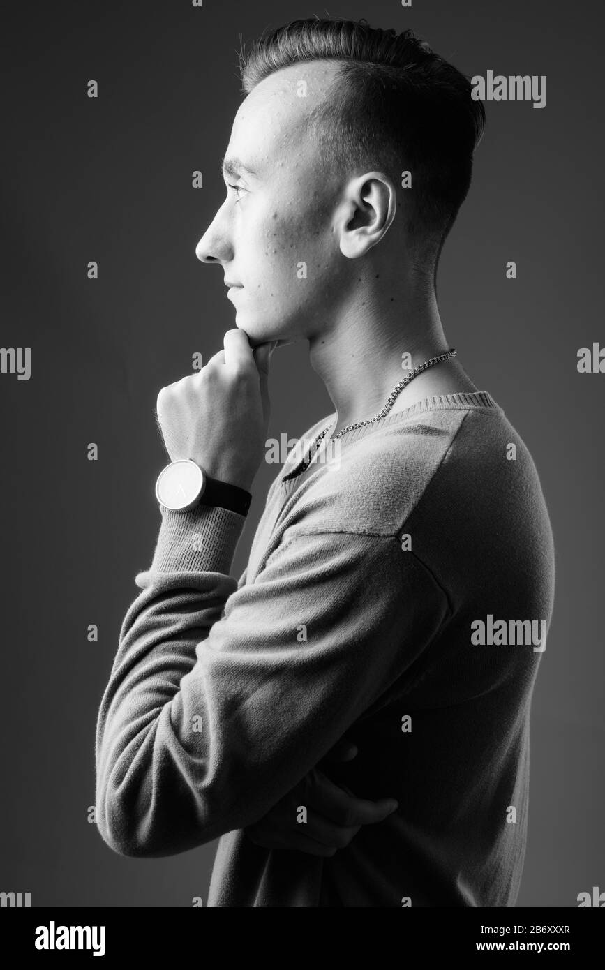 Portrait of young handsome man against gray background Stock Photo - Alamy