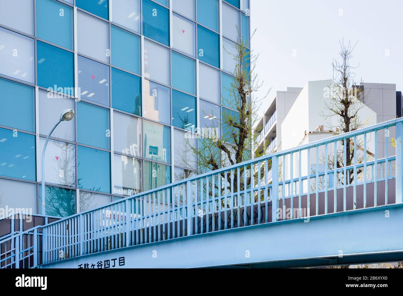 The NTT Docomo Yoyogi Building reflected in a blue and grey building in Shikjuku, Tokyo. Stock Photo